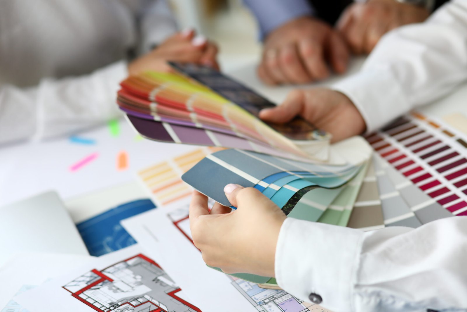 Focus on arms of hardworking businesswoman holding multicolored palette and thinking about important business project at workplace. Creative office concept. Blurred background